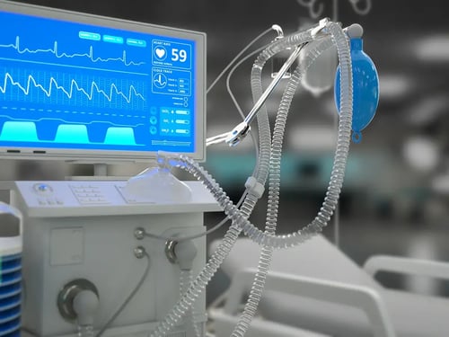 Close-up of a hospital ventilator with a blue screen displaying heart rate and graphs