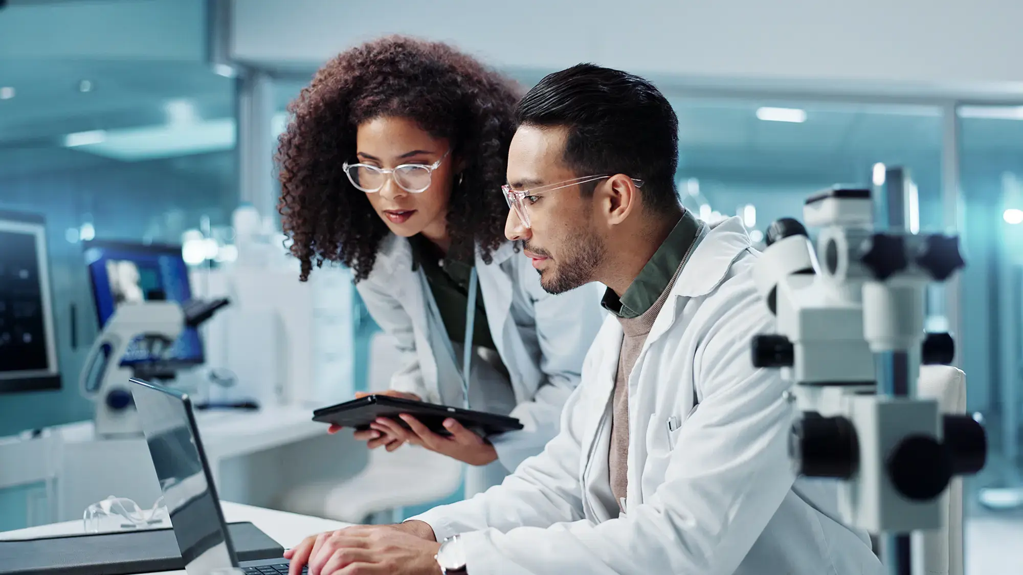 Two scientists in lab coats work intently in a modern laboratory
